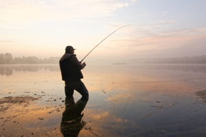 Photo of a fisherman fishing in a vast lake
